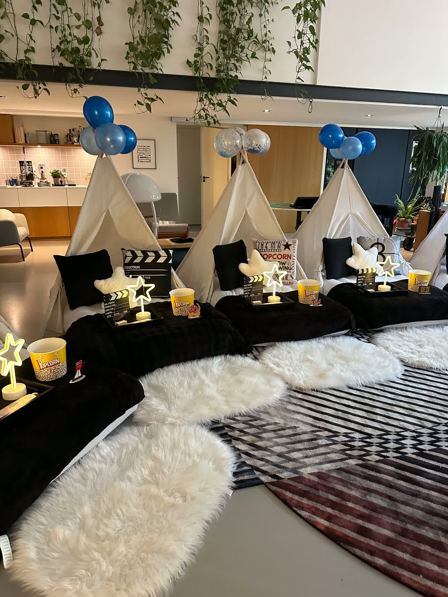 Lights, Camera, Cozy teepee sleepover with black bedding, clapperboards, popcorn buckets and neon star lights