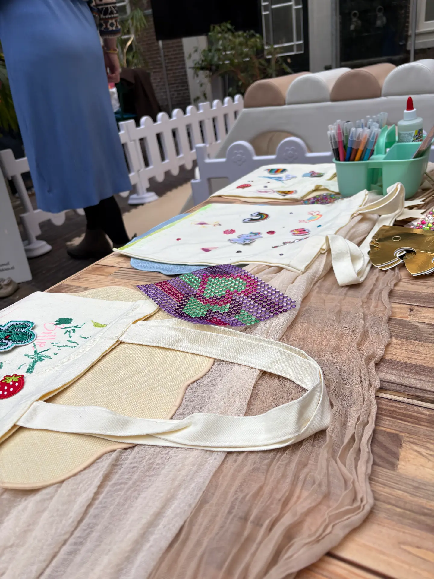 Tote bags, patches and markers laid out for a Mini Munchkins workshop