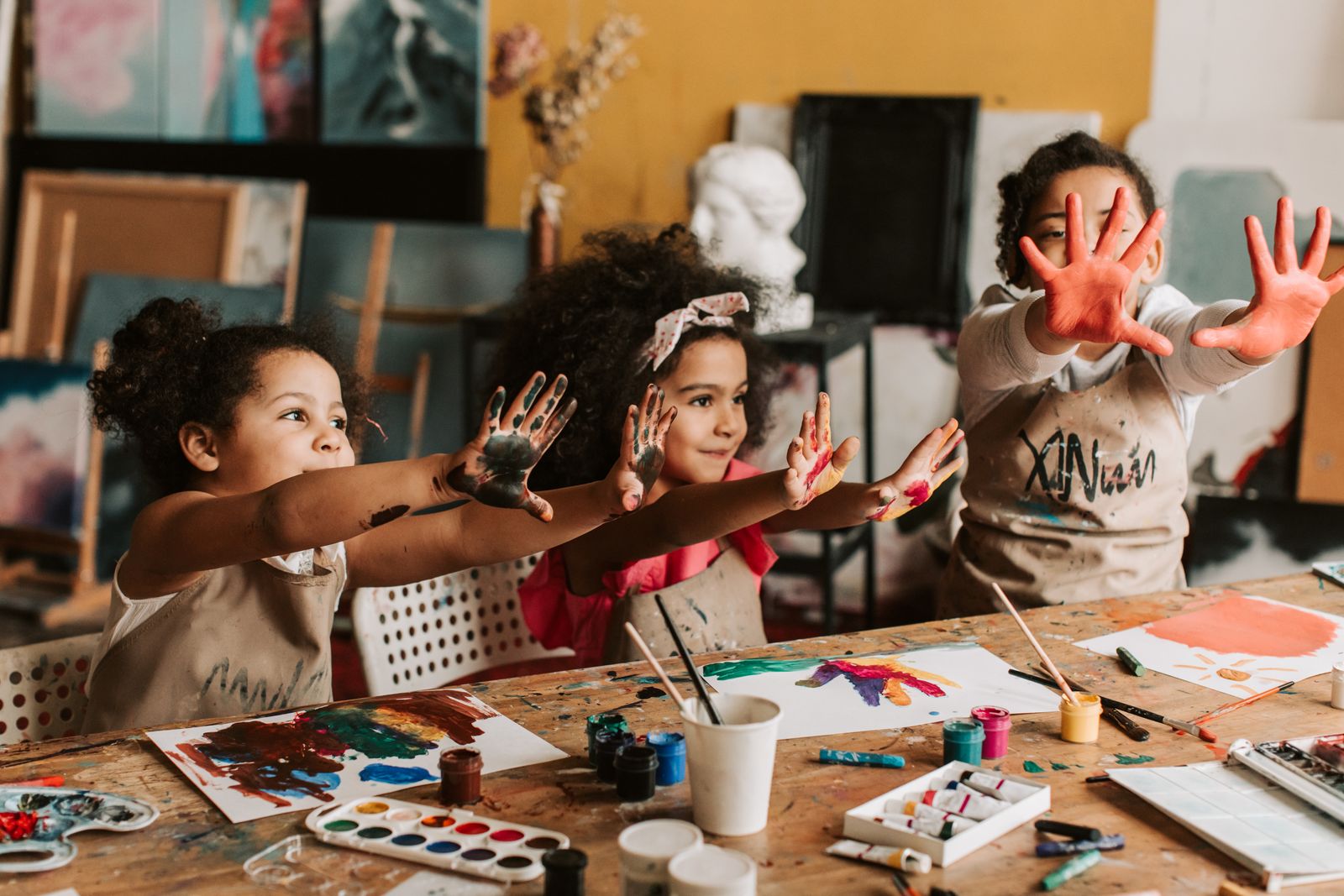 Children showing their paint-covered hands during an art workshop