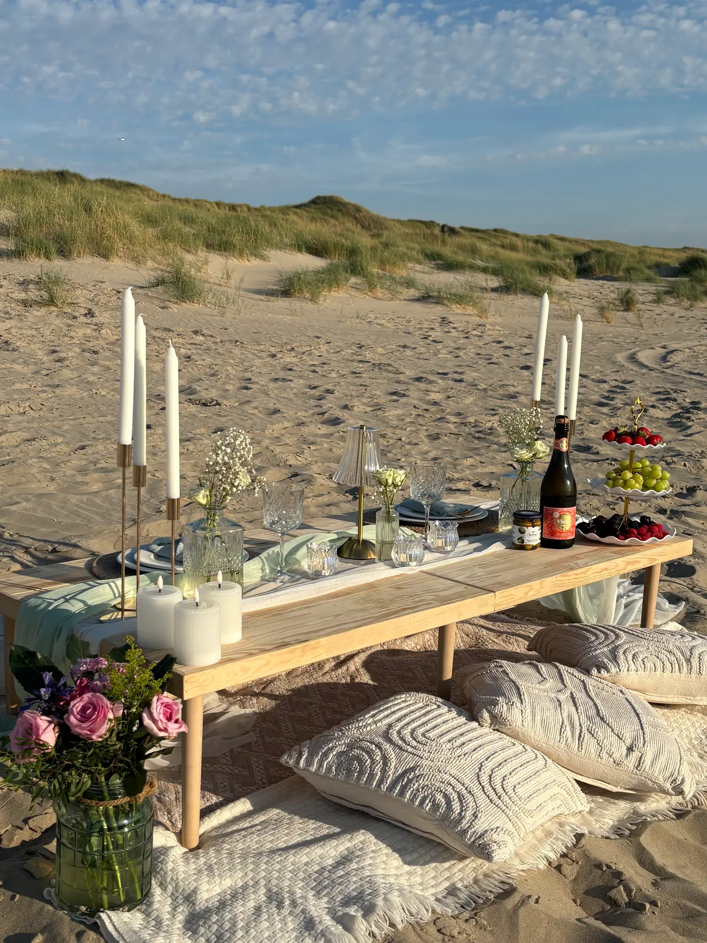 Styled low picnic table on the beach at sunset
