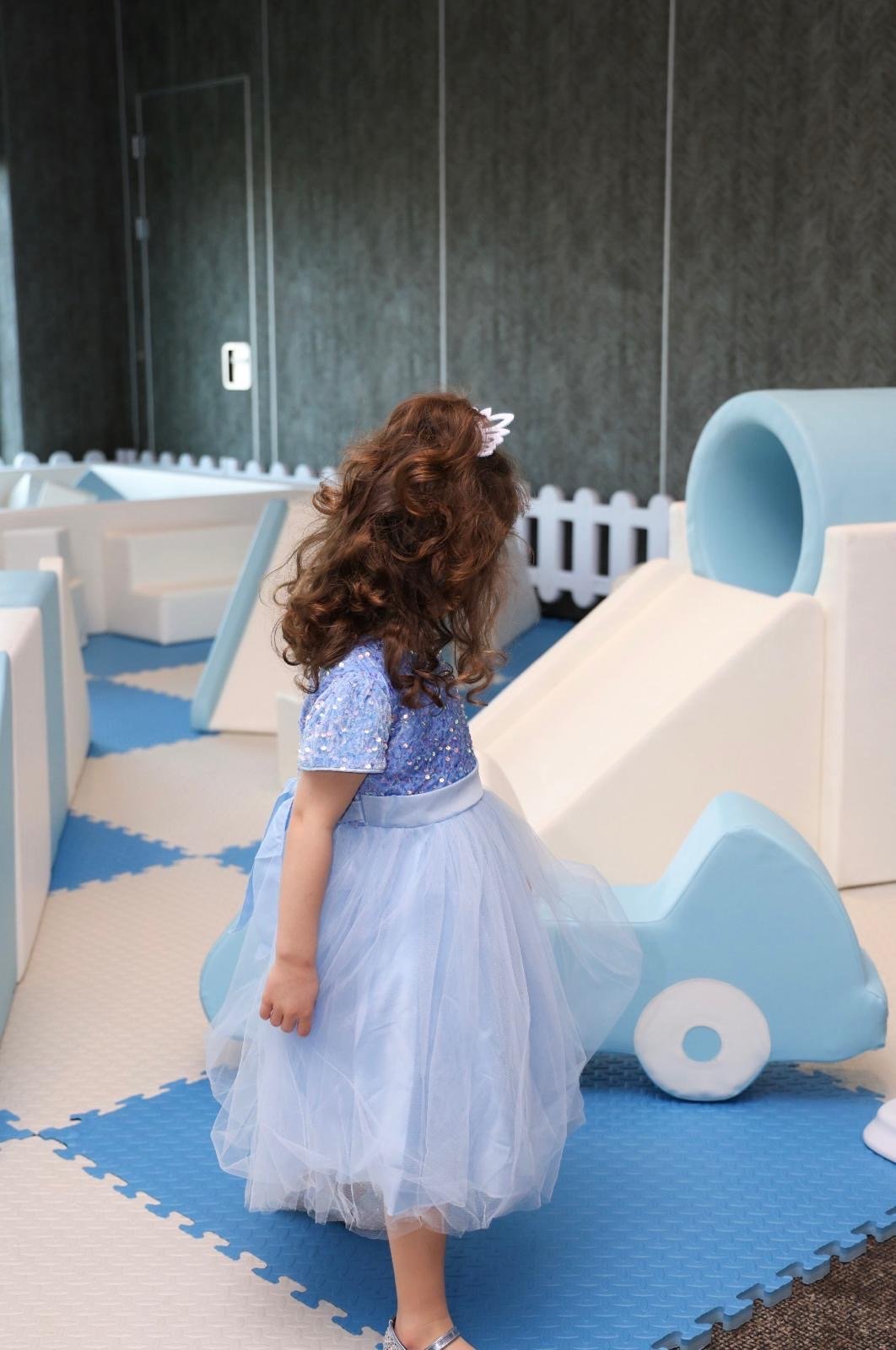 A little guest exploring a blue and white Mini Munchkins soft play area