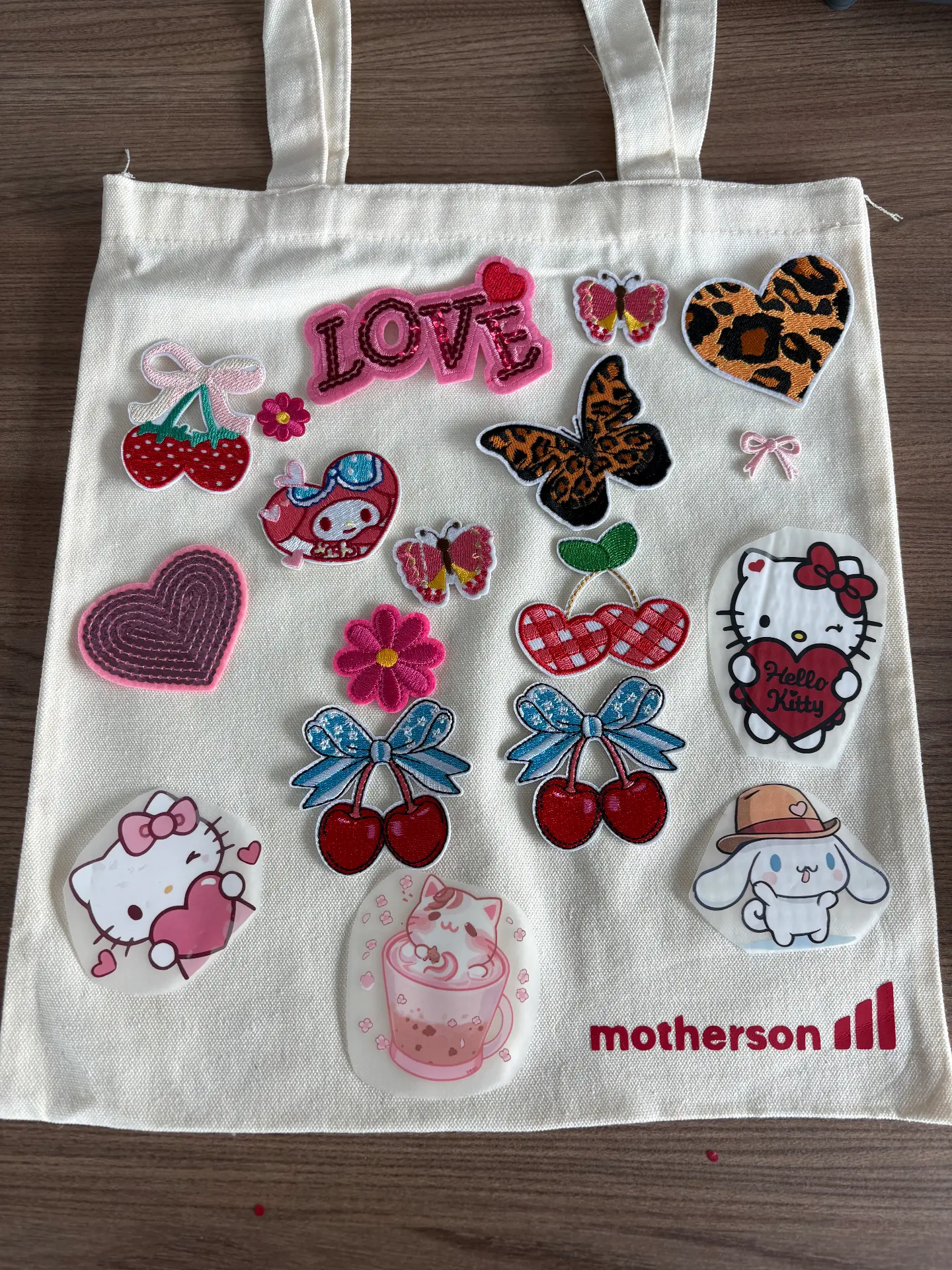 Colourful iron-on patches arranged on a tote bag for a Mini Munchkins patch design workshop