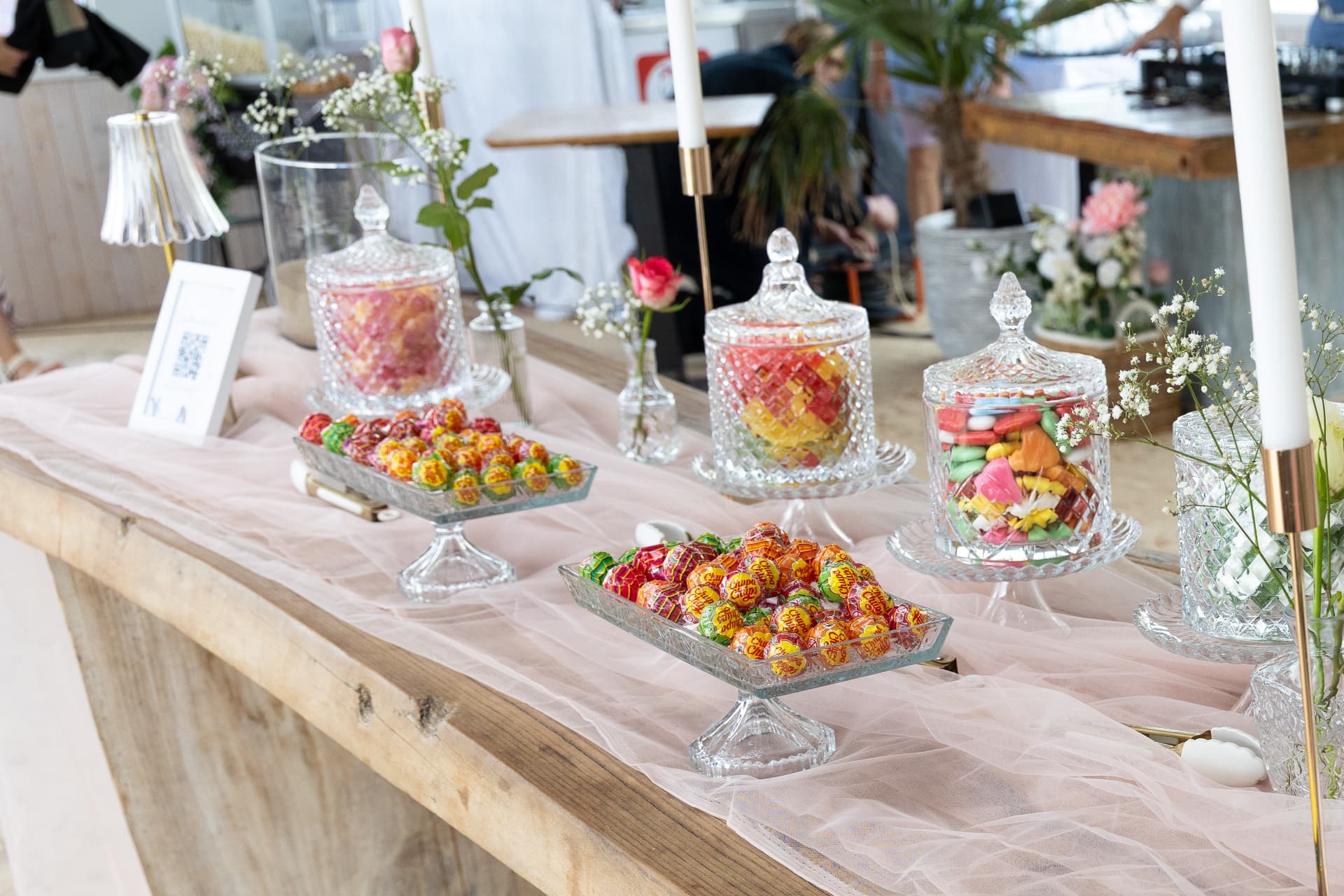 Sweet table with crystal jars and lollipops on a blush runner