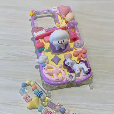 A hand mirror decorated in the decoden style with colourful cream and charms