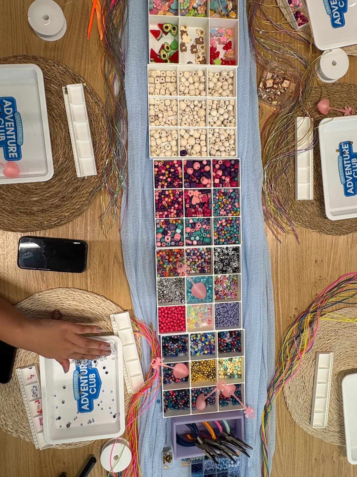 A bracelet-making table with trays of colourful beads at a Mini Munchkins workshop