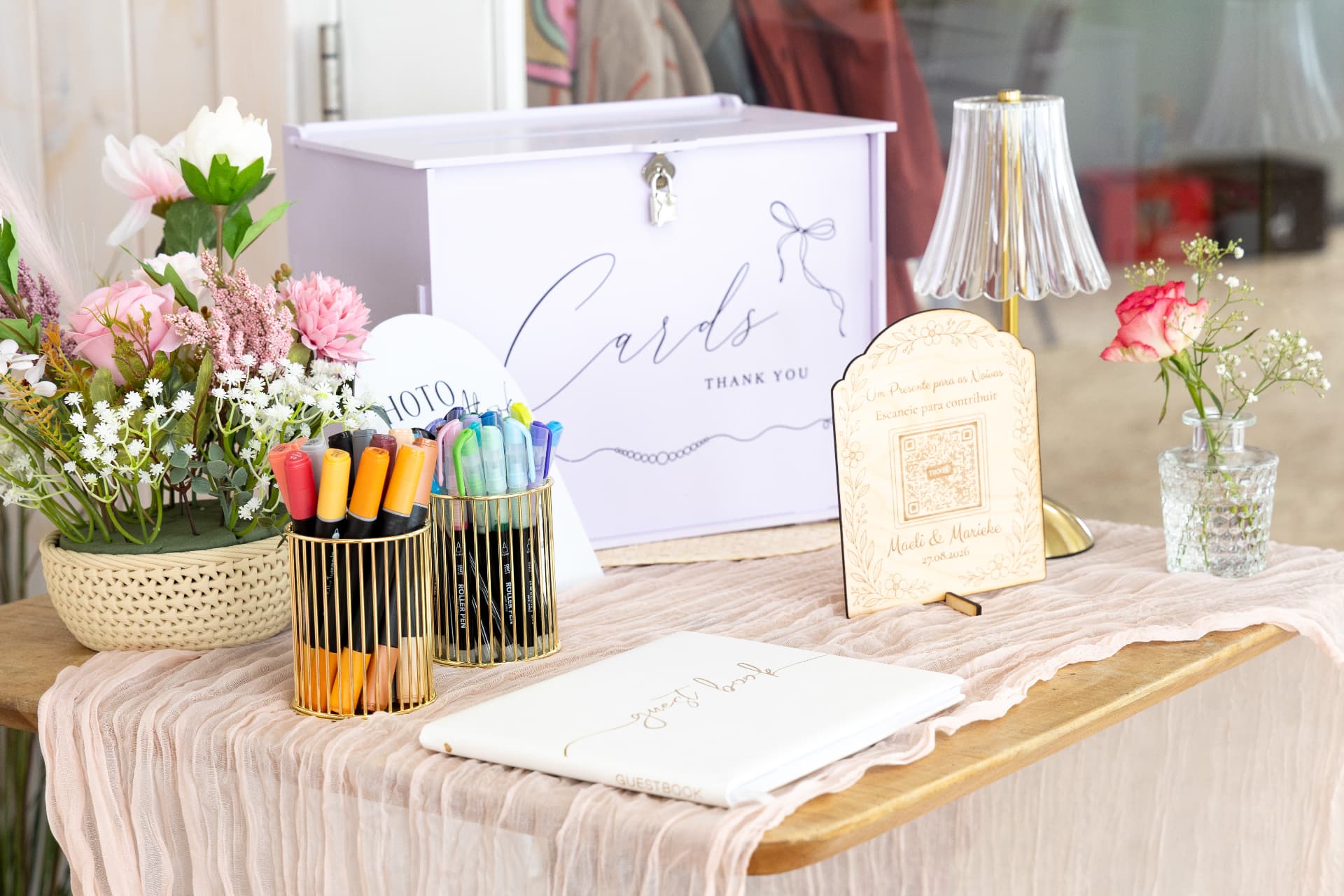 Cards and guestbook table with florals, pens and an engraved sign