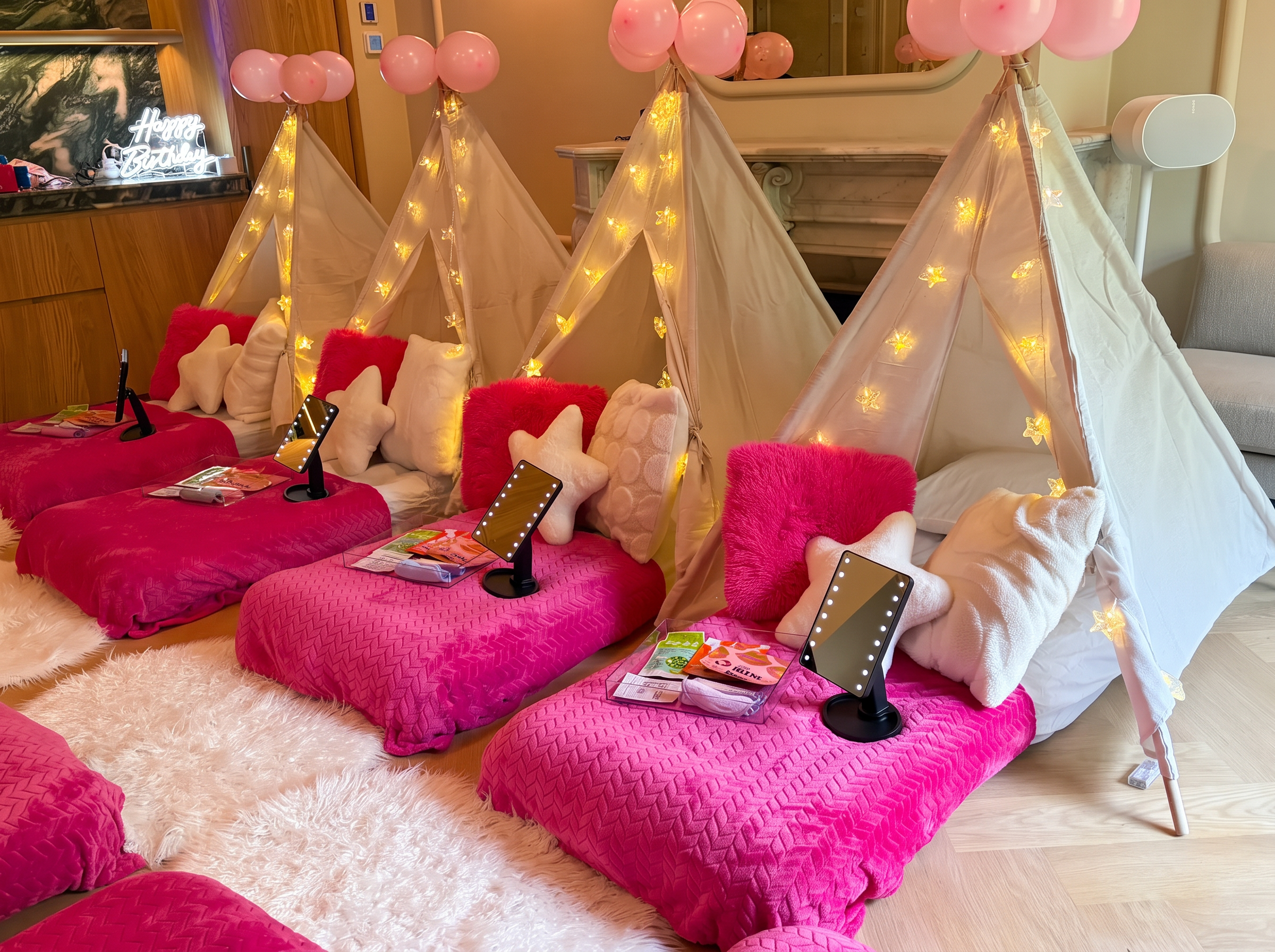 Spa teepee sleepover with pink bedding, star cushions, illuminated mirrors and fairy lights